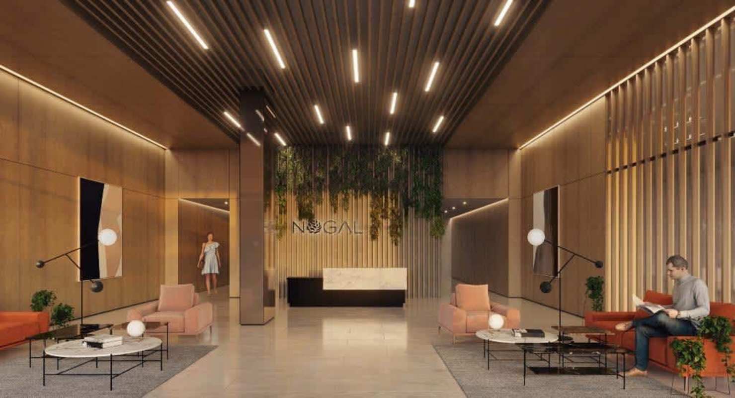 Bright open space with marble island kitchen, floor-to-ceiling windows, green sofa and balcony view at PH Nogal Panama