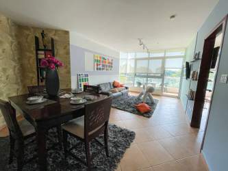 Equipped kitchen with granite countertop and breakfast bar in Coronado Golf Tower condo