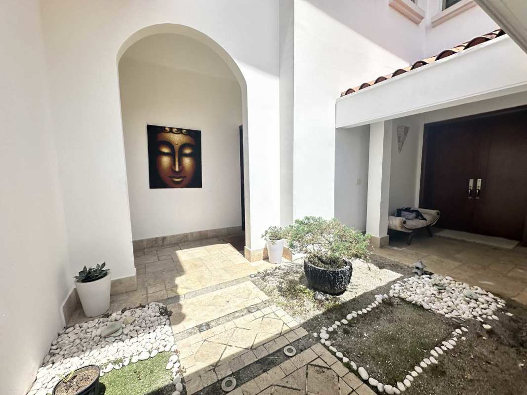 Double-height entrance hall with marble floors and spiral staircase in luxury home Panama