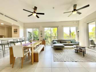 Contemporary living and dining space with access to covered balcony and garden views in luxury Panama condo