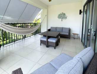 Large modern balcony with hammock and outdoor seating overlooking greenery in Buenaventura luxury resort