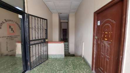 Corner view of two-story building with balcony apartments and urban street scene Colón Panama