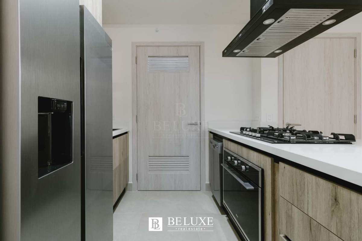 Contemporary kitchen with island cooktop, stainless appliances, light cabinetry PH Ocean House Santa Maria Panama