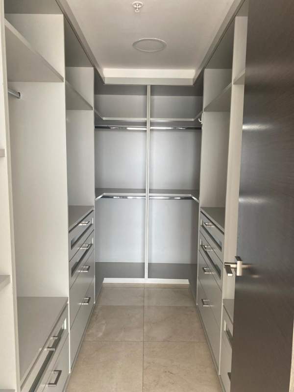 Luxury walk-in closet with built-in cabinetry and drawers inside PH GreenGarden condo Panama
