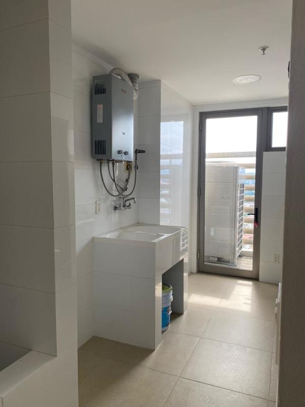 Laundry utility room with sink and tankless heater inside luxury condo PH GreenGarden Santa María Panama