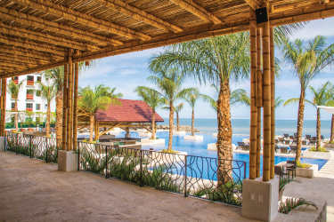 Covered terrace with bamboo roof overlooking infinity pool and Pacific Ocean in luxury beach resort Panama