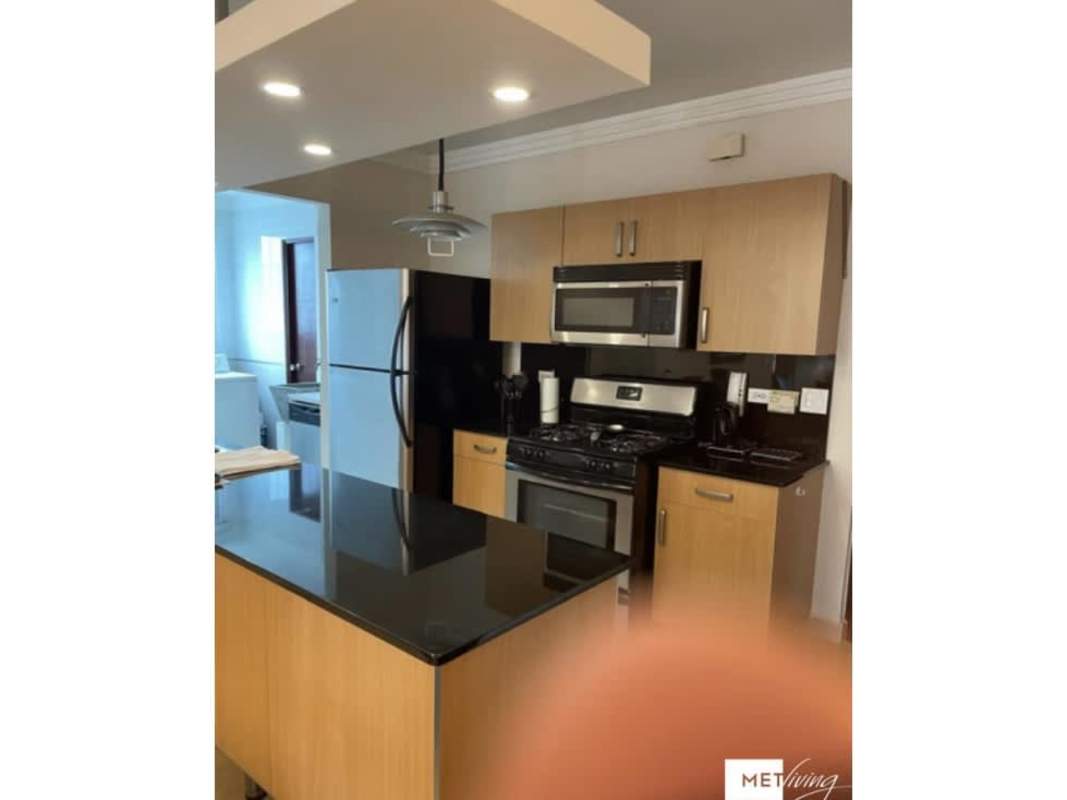 Modern kitchen with island, black granite counters and stainless steel appliances in PH Luxor El Cangrejo Panama