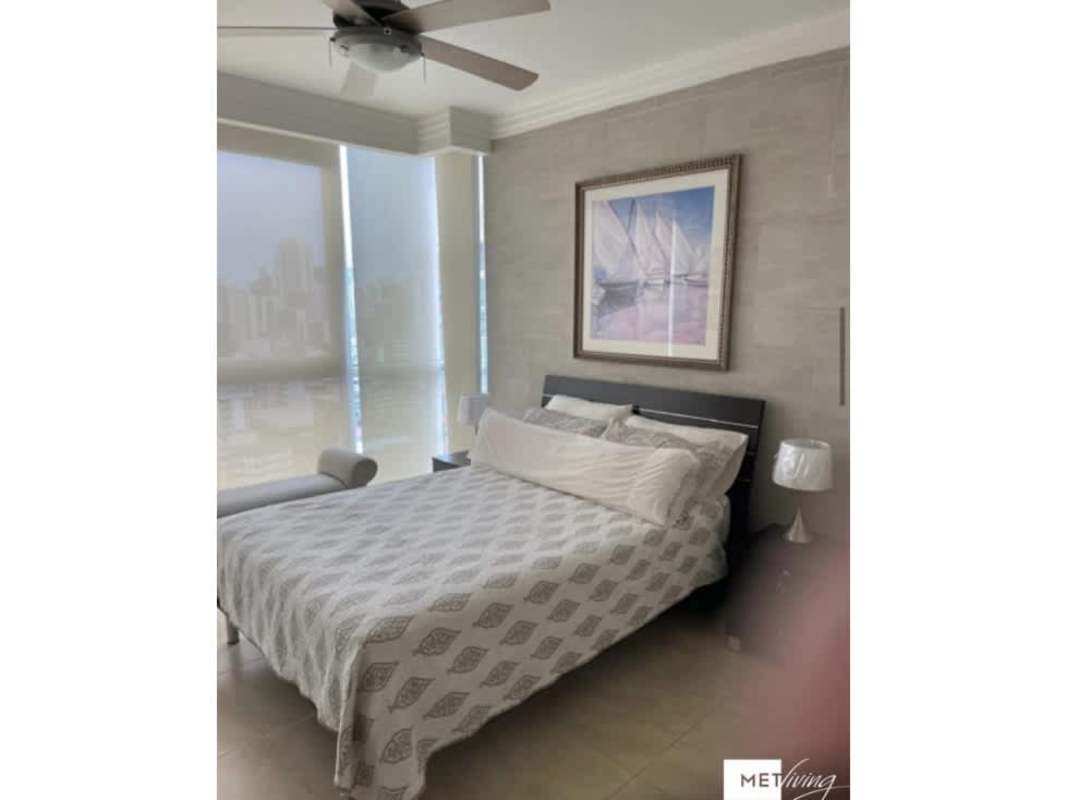 Bedroom with large window, city skyline view, ceiling fan and closet at PH Luxor Panama City