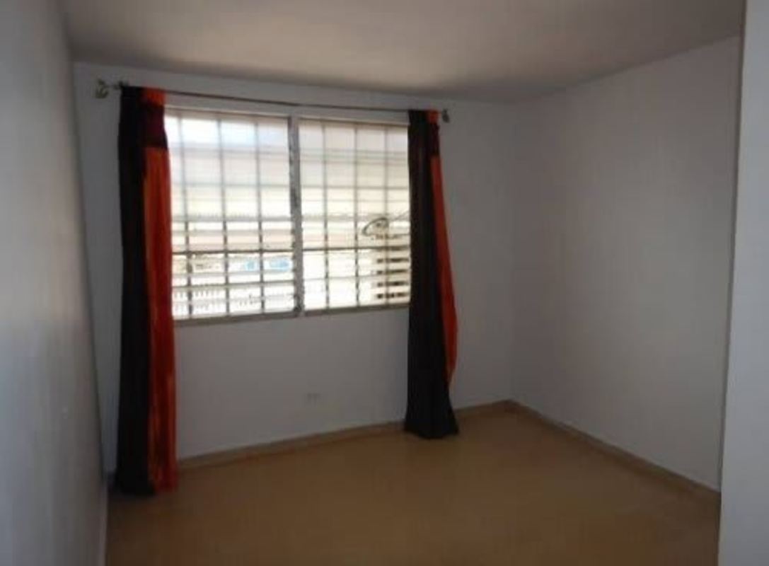 Spacious empty bedroom with security bars and white walls in Villa Lucre Panama