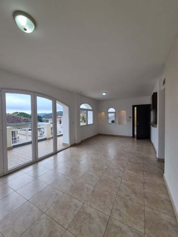 Modern living space with large glass doors leading balcony with tropical views