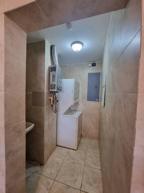 Laundry utility area with stacked washer dryer & water heater in Tucan Country Club condo