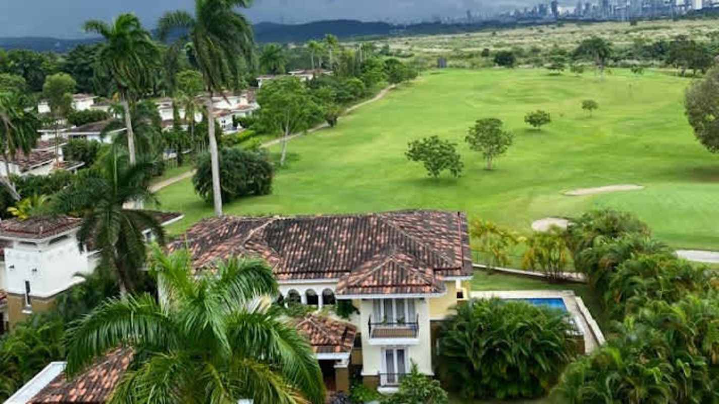 Aerial view of Mediterranean-style property overlooking golf course with pool, lush palms at Tucan Country Club