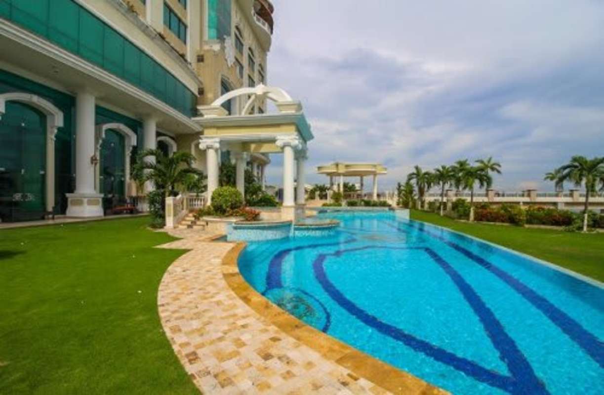 Enclosed patio sunroom with dining area wicker sofa and ocean backdrop Bellagio Tower
