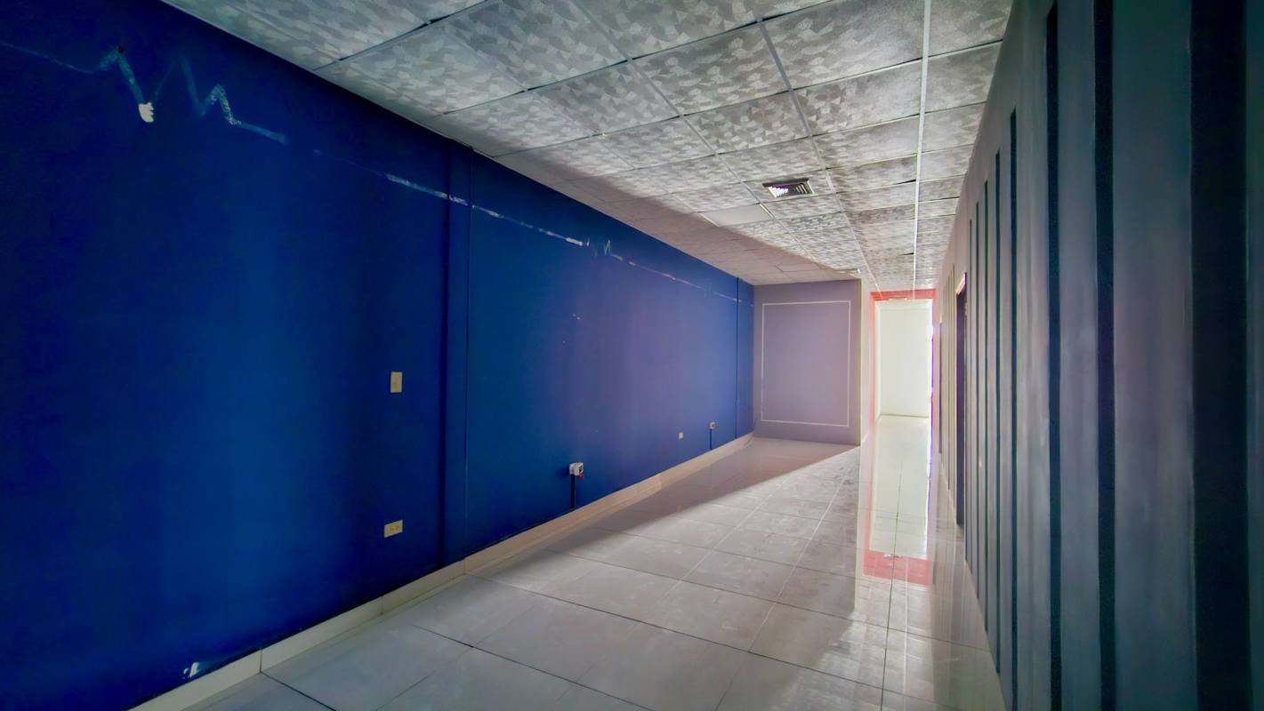 Commercial corridor with blue walls, motivational art 'Until it's done', tiled floor Display Plaza Panama