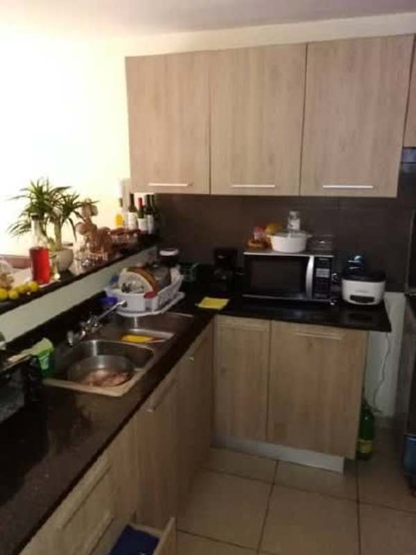 Compact kitchen with light wood cabinets and black countertops in PH Villa Andalucía Panama