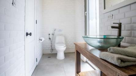 Spacious bathroom with glass vessel sink, tile walls, wood vanity, large window