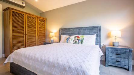 Minimalist bathroom with vessel sink, wood vanity, white tile, designer fixtures in Playa Venao villa