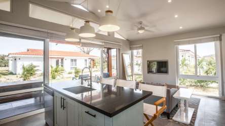 Modern kitchen with large windows island sink pendant lights Playa Venao villa