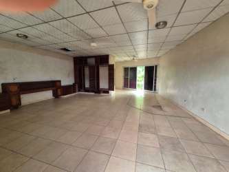 Large living room unfurnished with tiled floor, ceiling fan, built-in cabinets and garden access in Colón house