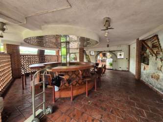 Indoor entertainment area with circular bar and rustic brick features in Colón home for sale