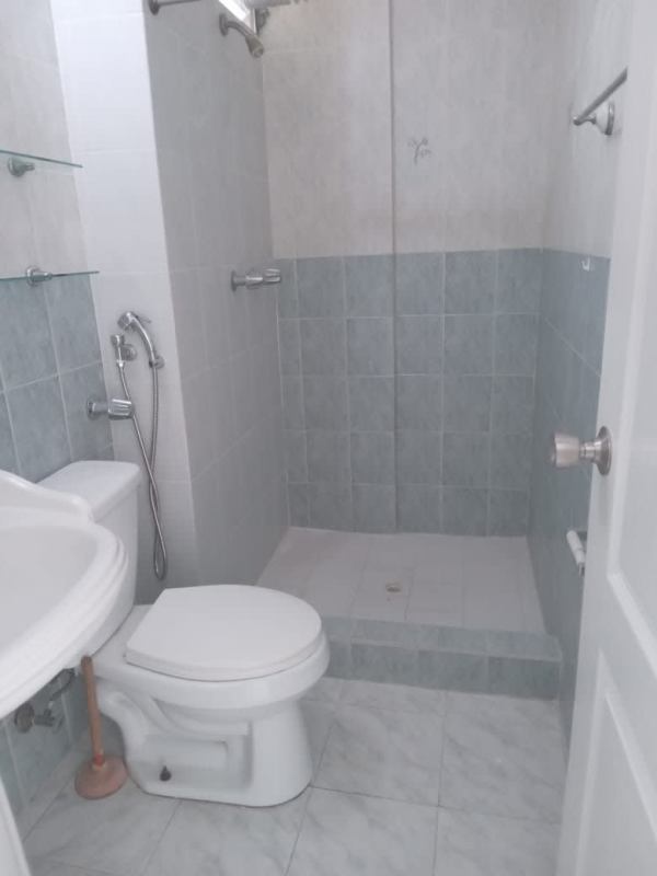 Compact bathroom with shower, pedestal sink, beige tiles PH Miraflores Plaza Betania Panama
