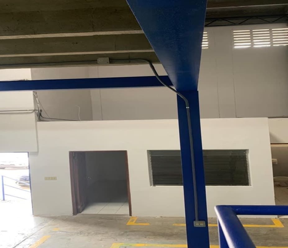 Warehouse office area with enclosed white-painted structure blue steel framing Panama City