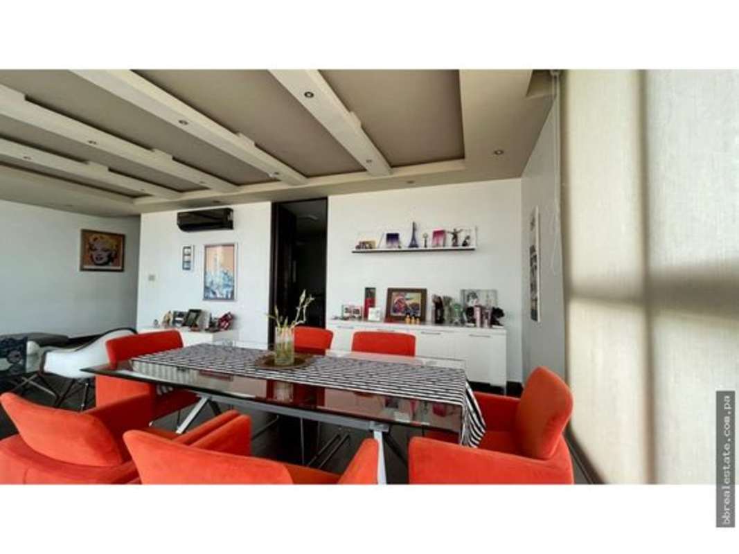 Modern dining space with red chairs, glass table and ceiling details in PH Soho Tower Costa del Este Panama