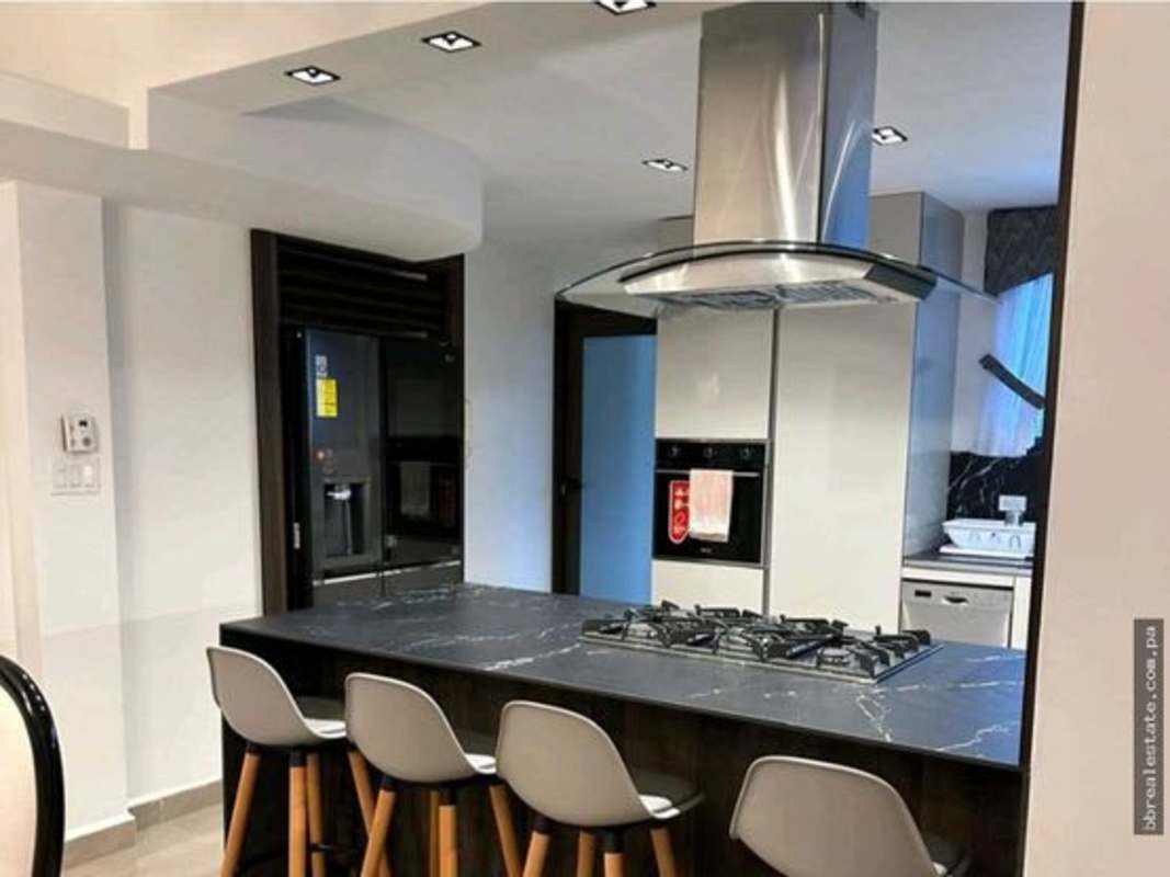 Island kitchen with gas cooktop, black marble countertops, oven and fridge PH Country Park San Francisco Panama