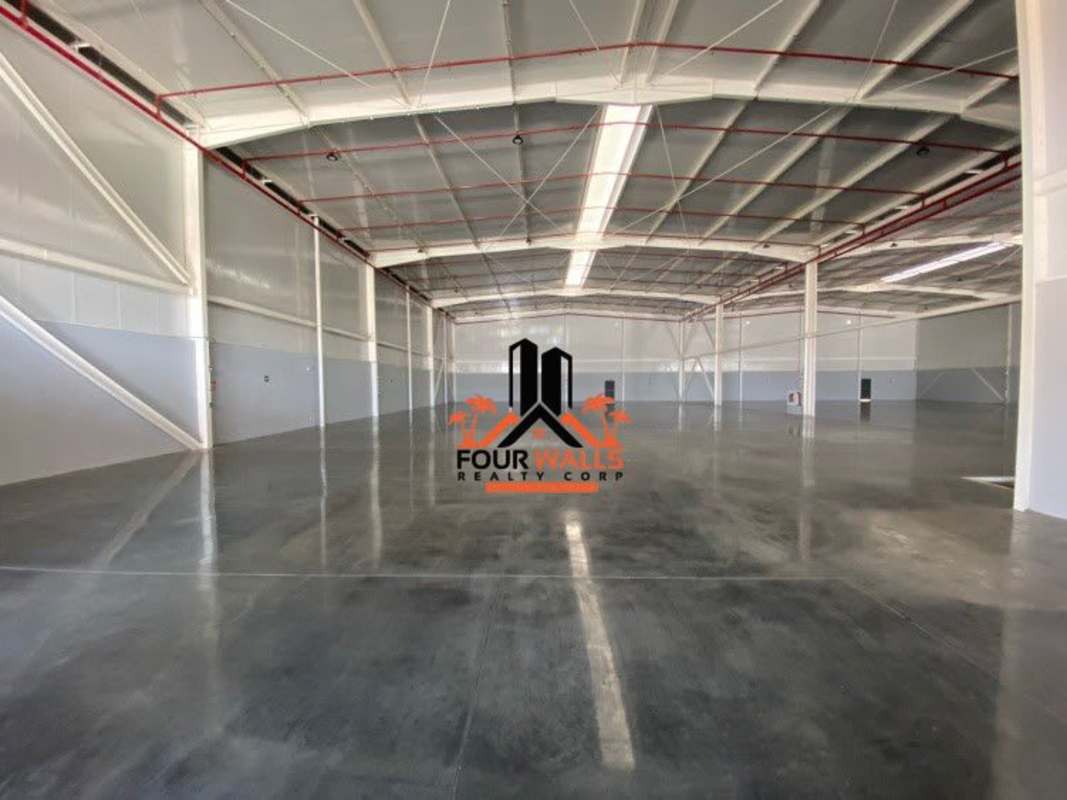 Modern industrial warehouse exterior at Panapark Free Zone featuring loading docks and wide access roads in Panama City
