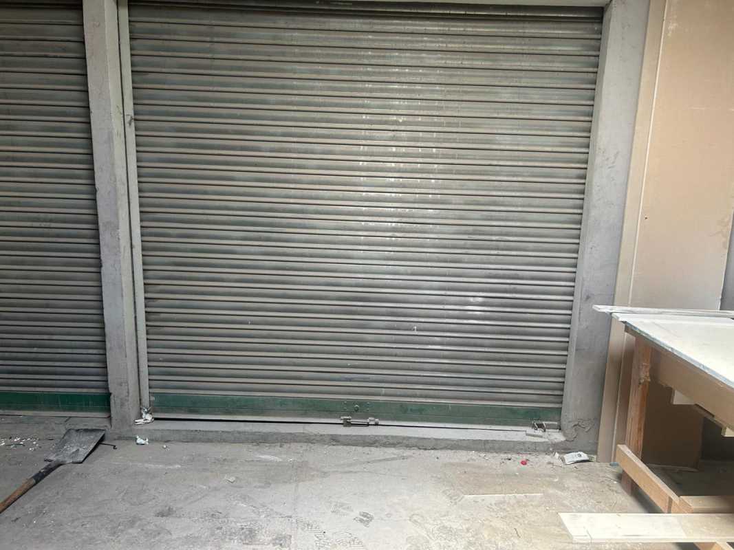 Warehouse or shop space interior with metal shutter and construction materials, Panama City
