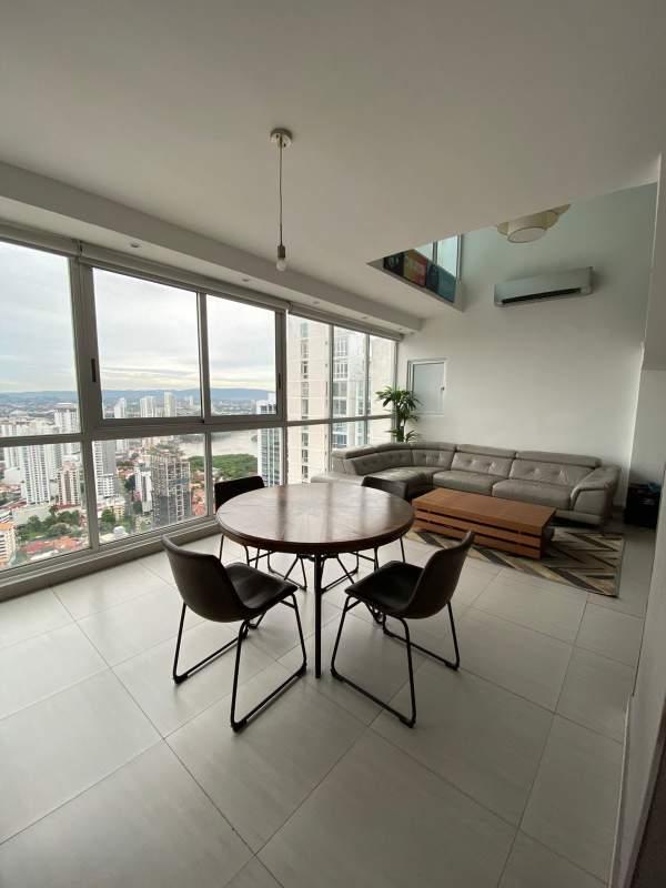 Modern dining area inside loft apartment with skyline views in Coco del Mar Panama City