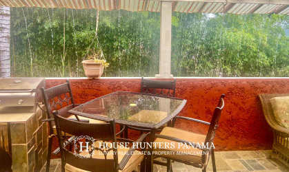 Covered patio with dining area, garden view and mountain backdrop in luxury Victorian home Valle Escondido Boquete