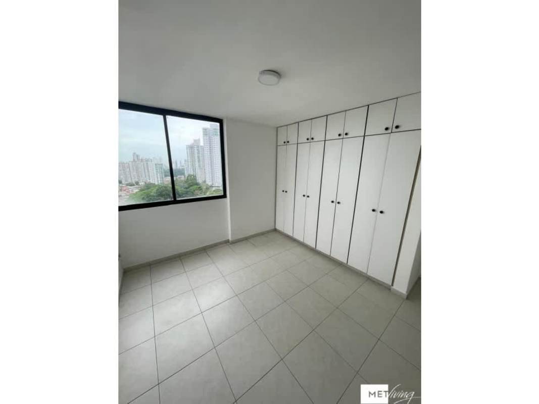 Bedroom featuring large window city view and built-in closets PH La Loma Residences