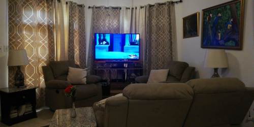 Spacious living room with vaulted ceiling, tile floors, and windows at Cuesta del Sol David Panama