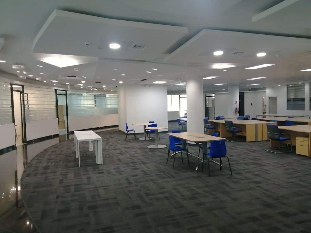 Open workspace with blue chairs and modular desks semi-furnished in PH BICSA Tower Panama
