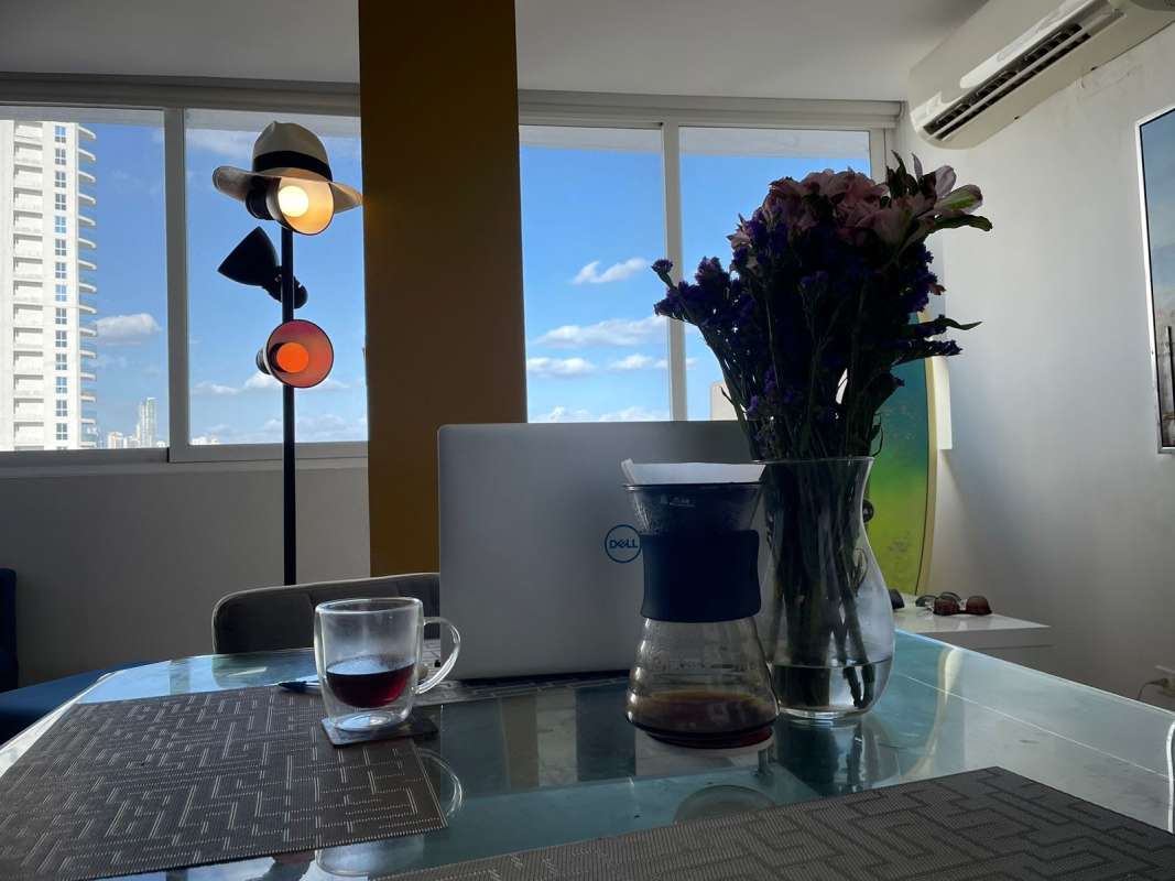 Modern minimalist space with oceanview windows, surfboard and TV in PH Bay View Panama City