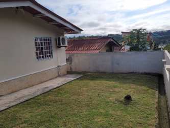 Side exterior view of house with yard, AC unit, privacy wall in Vista Alegre Panama.