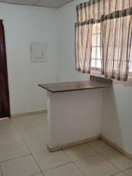 Compact kitchen with bar counter, tile floor, window in Vista Alegre house.