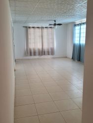 Spacious living room with tiled floors and ceiling fan in Vista Alegre house Arraiján Panama.