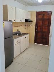 Traditional kitchen with cabinets, refrigerator, and sink in house Panama.
