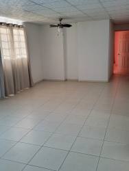 Front lawn and tiled porch of single-story cream house in Panama.