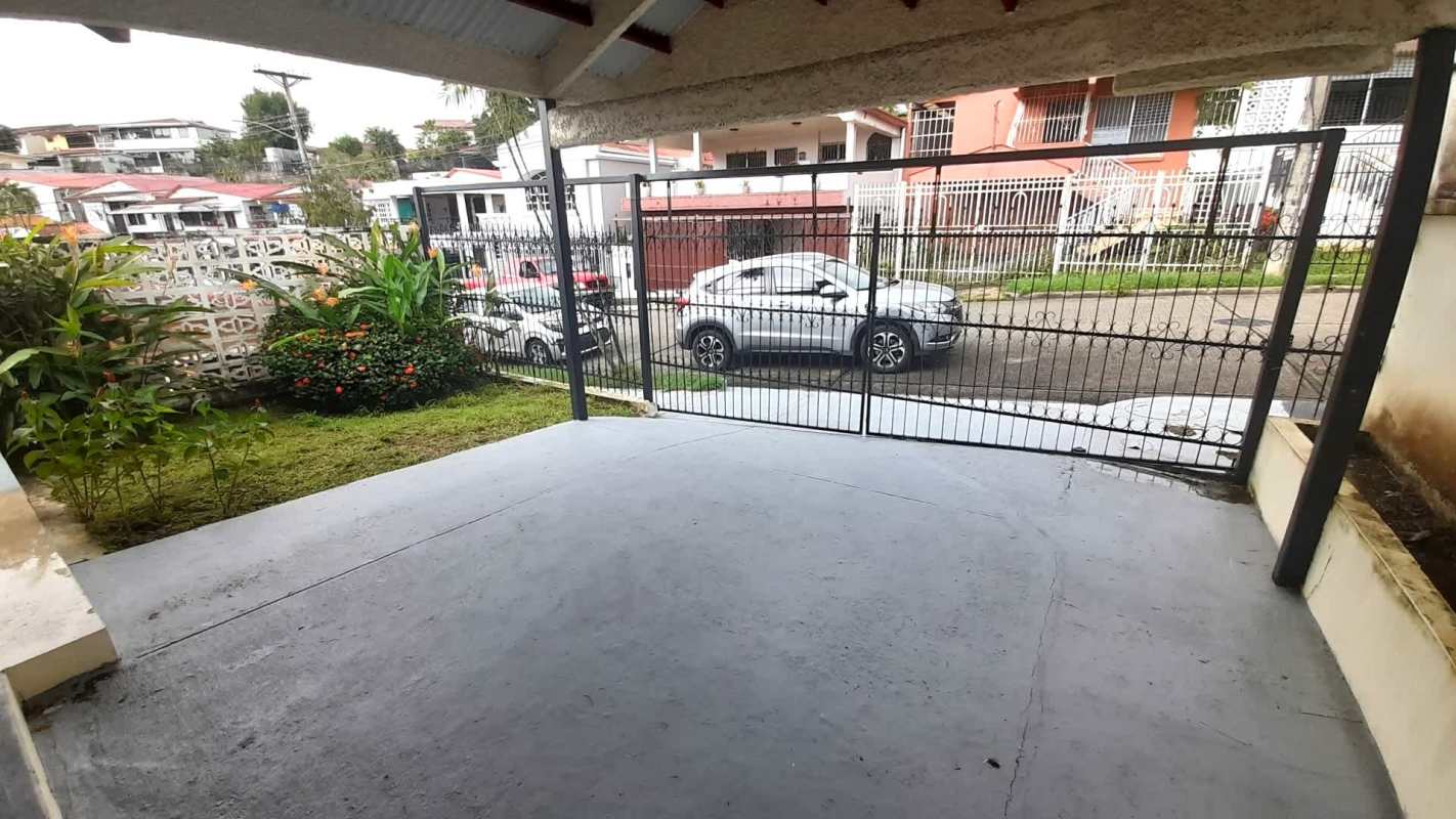 Porch with security gate and decorative wall, garden plants at Panama house