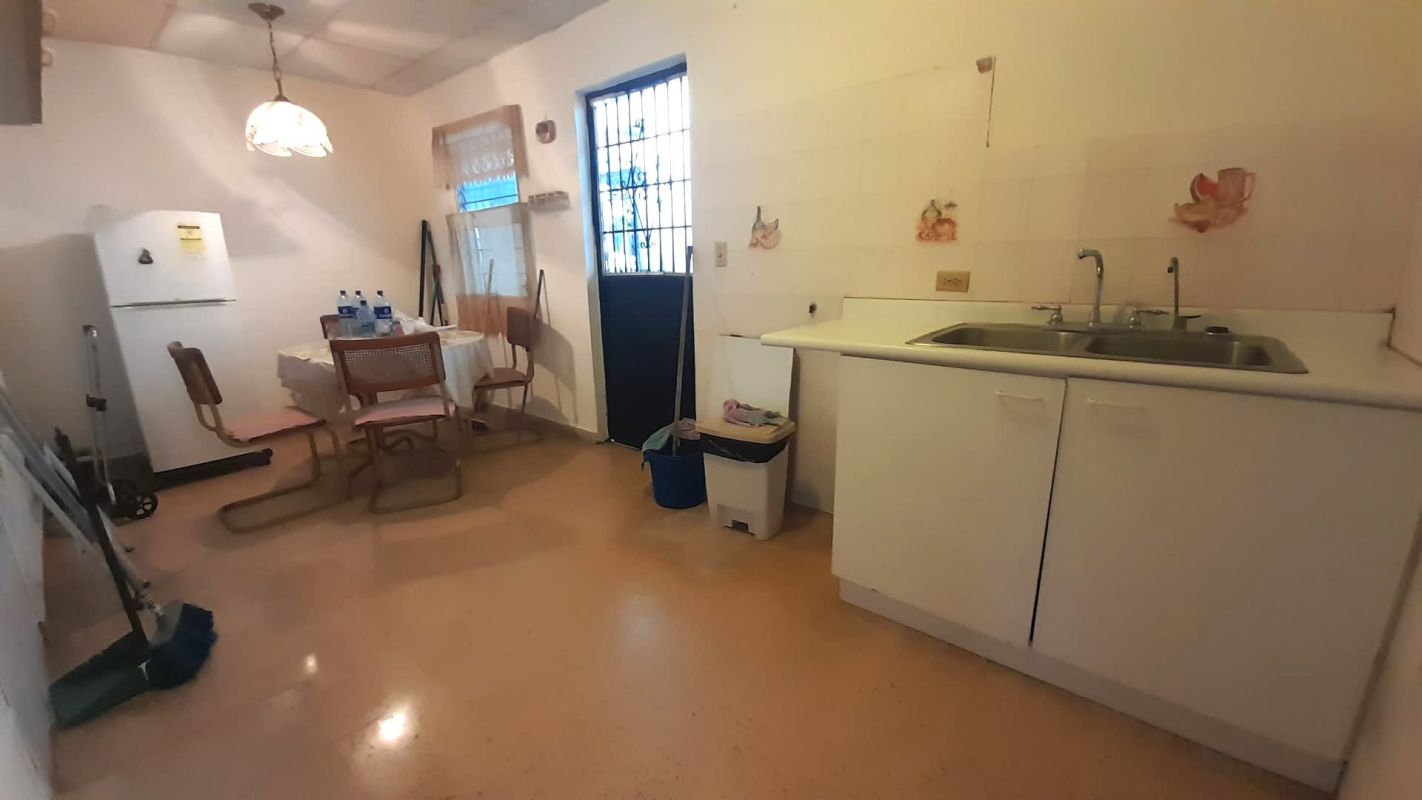 Kitchen with white cabinets, refrigerator, sink and dining table in Altos del Chase Panama