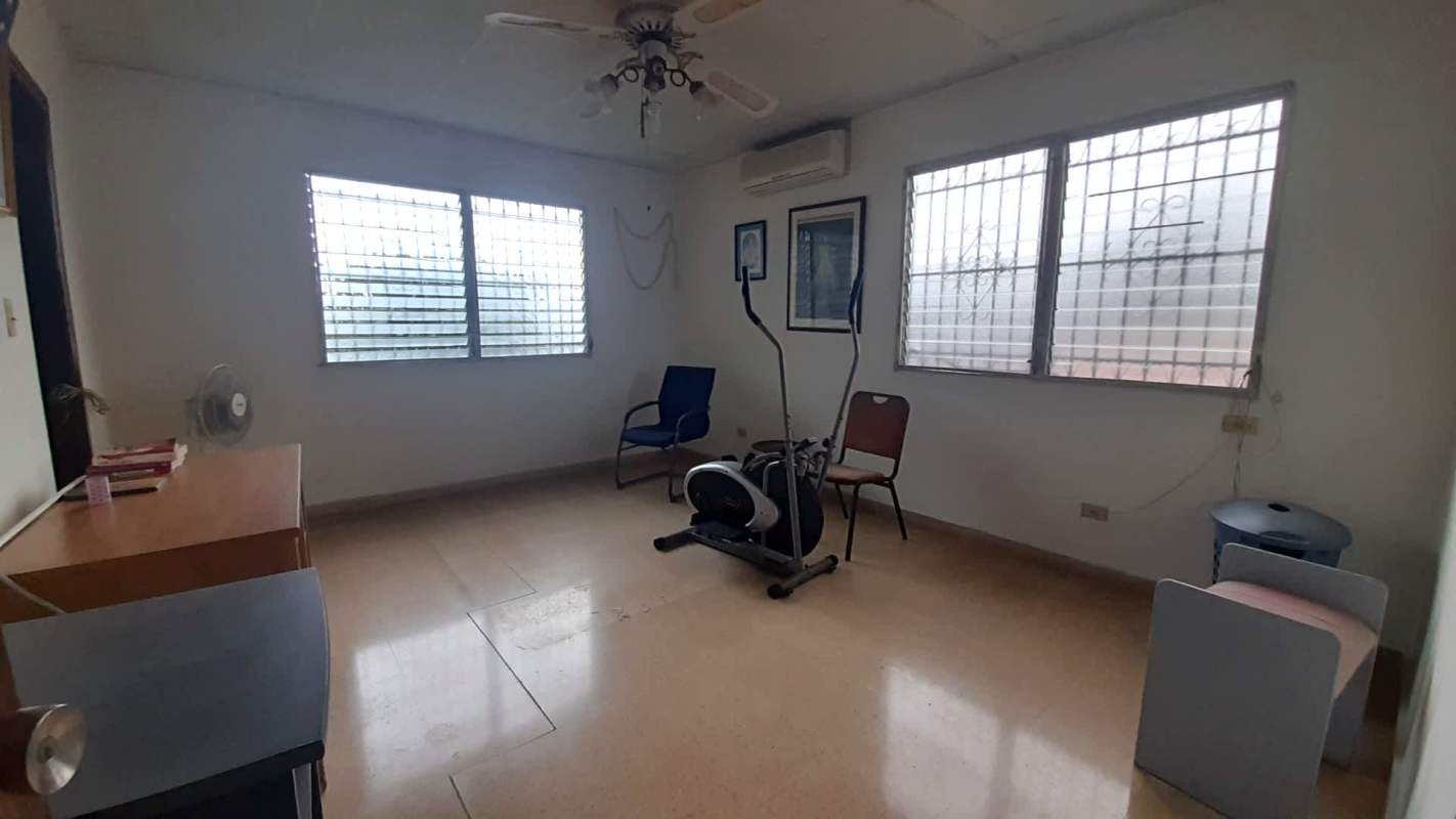 Large room with exercise equipment, windows and tile floor in Altos del Chase house Panama