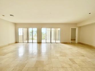 Bright living room with floor-to-ceiling glass and ocean views in Puntarena condo Panama