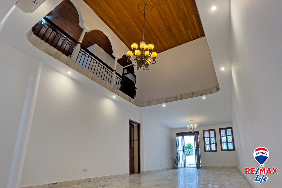 Bright living room with double-height ceiling, chandeliers, marble floors in La Alameda Betania house