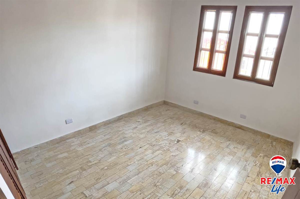 Bedroom with wooden shutter closets, tile floors in La Alameda Betania Panama