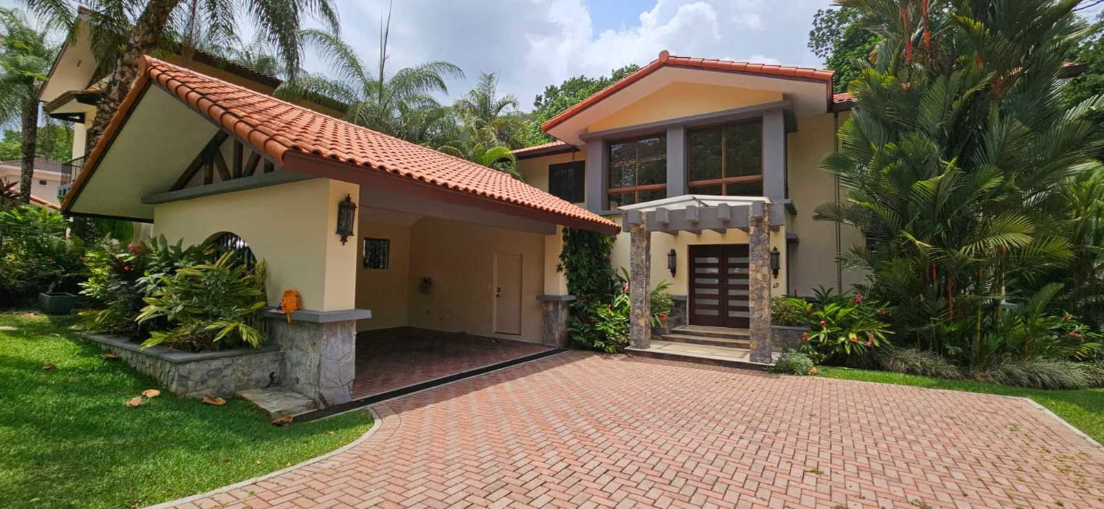 Mediterranean-style facade with tiled roof, stone accents, lush landscape at luxury Camino de Cruces house