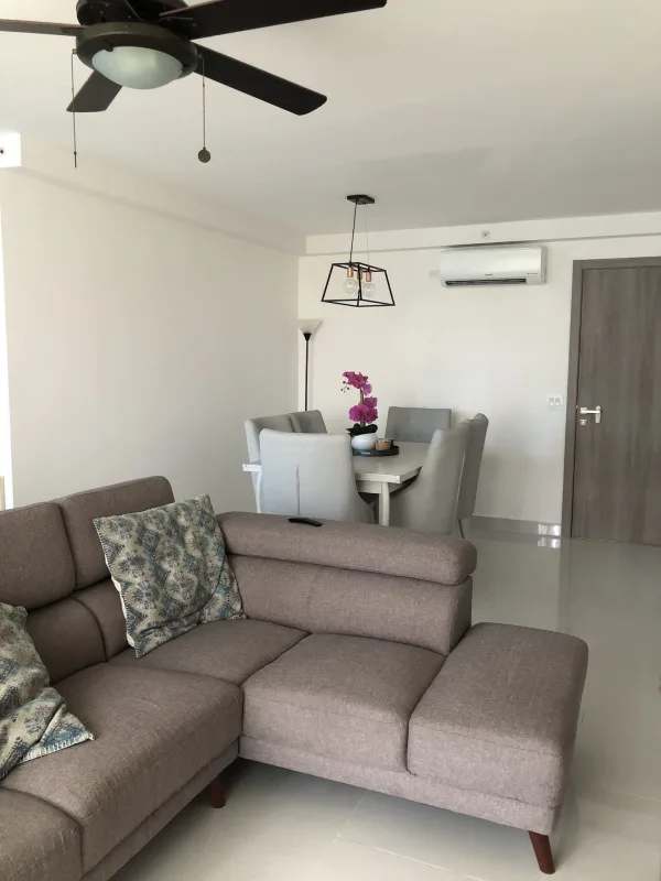 Modern white kitchen with breakfast bar, appliances and large window at PH Argentina Panama City