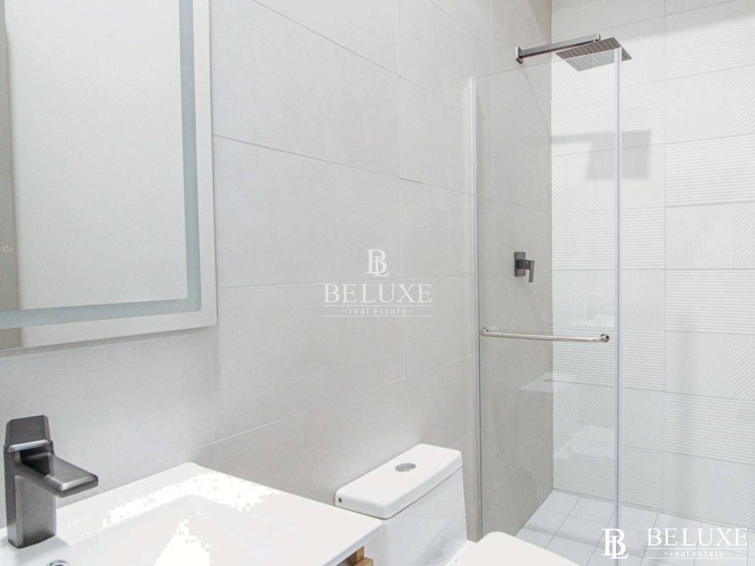 Minimalist bathroom with glass shower in Seaside House Panama City